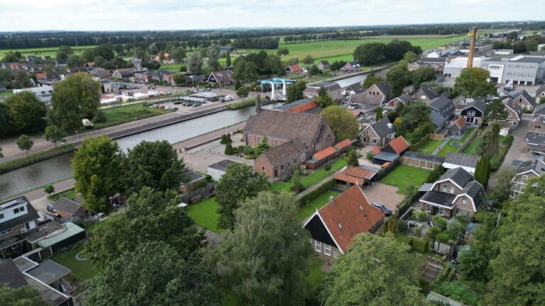Droneshot van Vriezenveen met diverse gebouwen en kanaal
